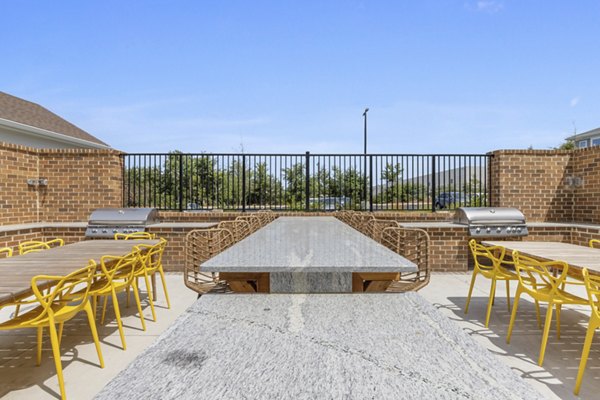 Patio area at Broadstone Ayrsley Apartments featuring modern outdoor seating and lush greenery