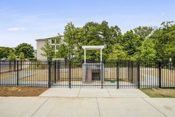 Dog park with agility stations and shaded seating at Broadstone Ayrsley Apartments, perfect for pet-friendly living in vibrant Charlotte