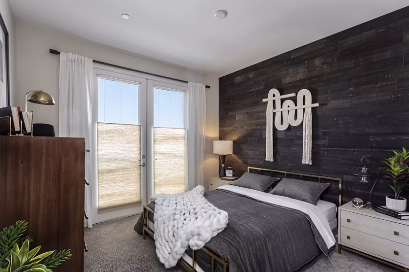 Cozy bedroom with modern decor at Prado West Apartments, featuring plush bedding and contemporary furniture for luxury living