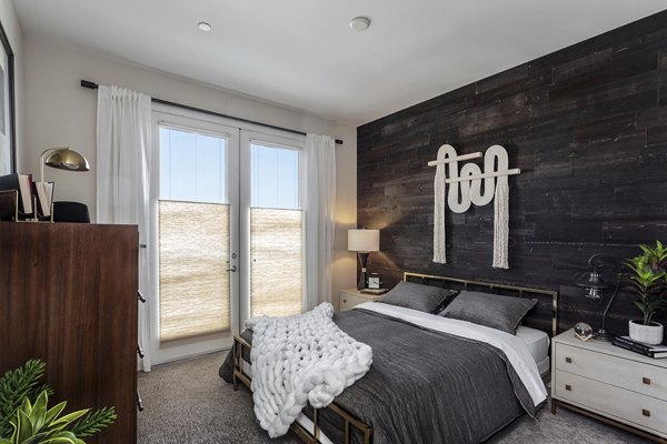 Cozy bedroom with modern decor at Prado West Apartments, featuring plush bedding and contemporary furniture for luxury living