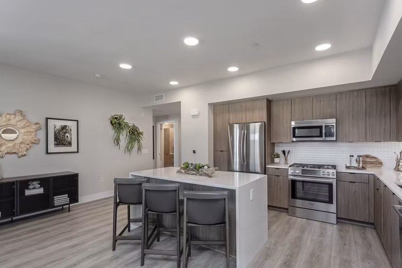 Modern kitchen with sleek island and stainless appliances in Prado West Apartments