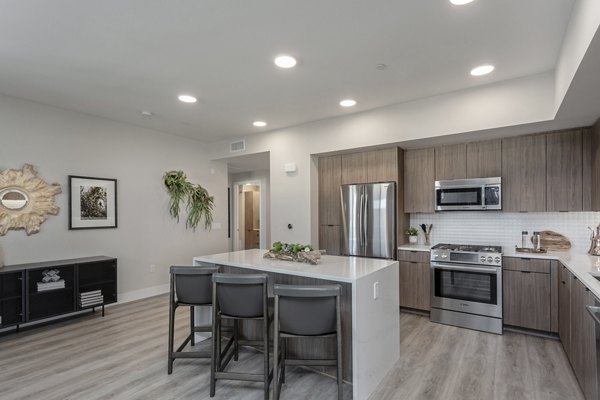 Modern kitchen with sleek island and stainless appliances in Prado West Apartments