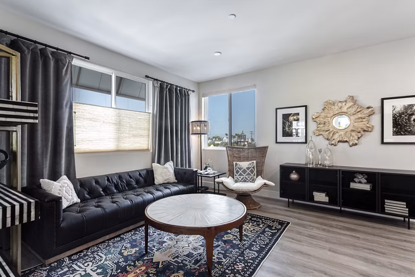 Spacious living room with modern furnishings and large windows at Prado West Apartments