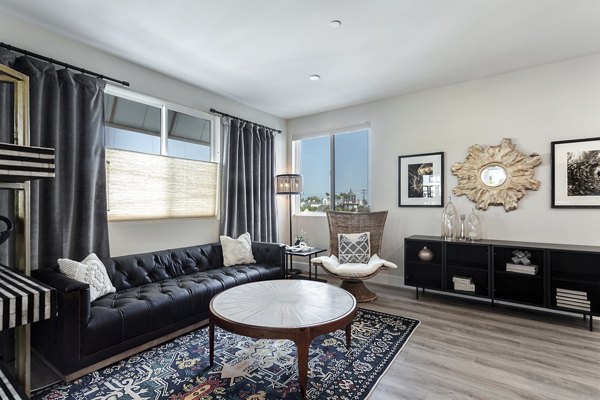 Spacious living room with modern furnishings and large windows at Prado West Apartments