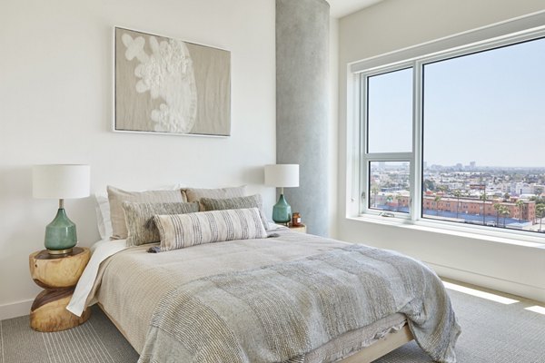 Cozy bedroom with modern furnishings at Jardine Apartments, offering luxury living by Greystar