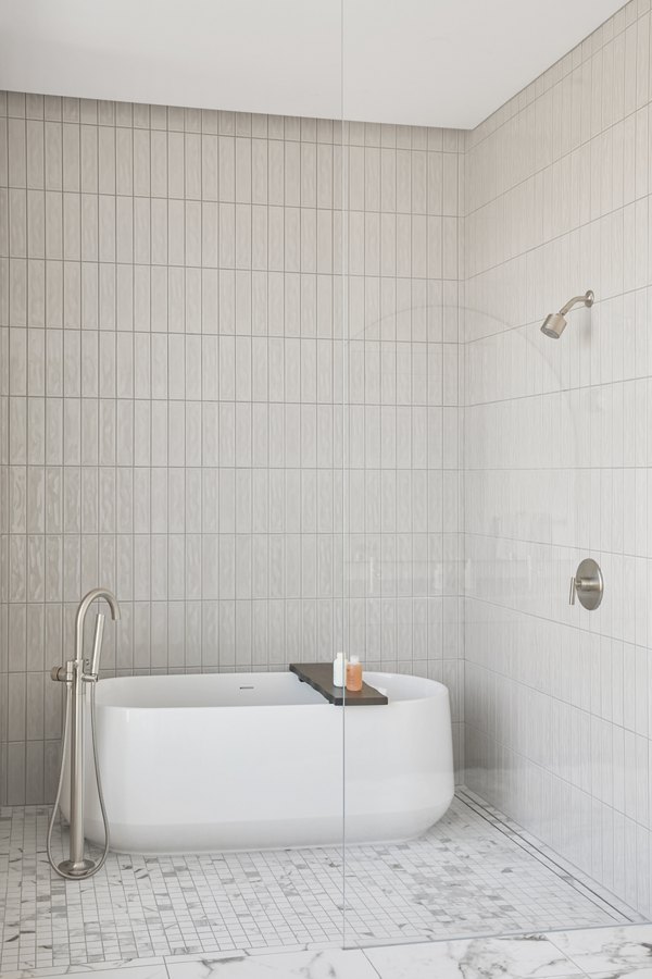 Bathroom with modern fixtures and elegant tile in Jardine Apartments, a luxury Greystar property