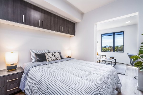 Cozy bedroom with modern decor and ample natural light in Exhibit at J Town Apartments