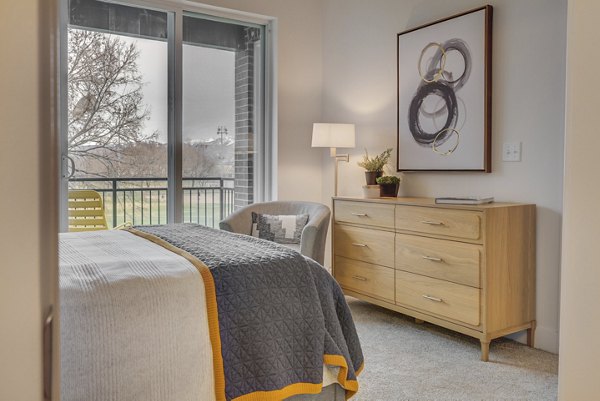 Harmony3900 Apartments: Modern bedroom with neutral decor and large window providing natural light