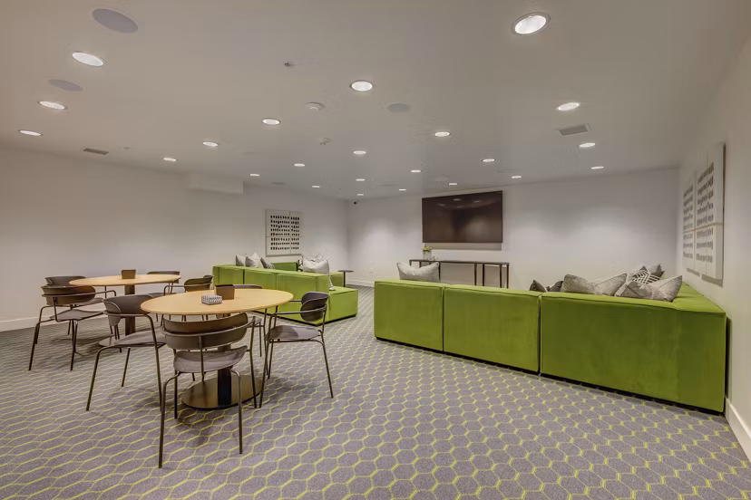 Theater room with plush seating and large screen at Harmony3900 Apartments