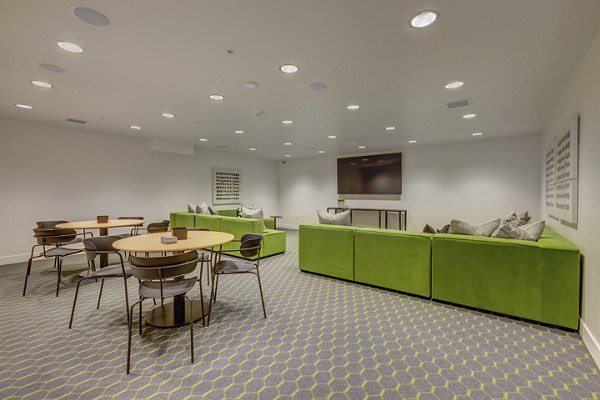 Theater room with plush seating and large screen at Harmony3900 Apartments