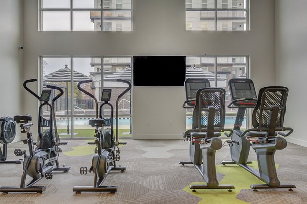 State-of-the-art fitness center equipped with modern exercise machines at Harmony3900 Apartments
