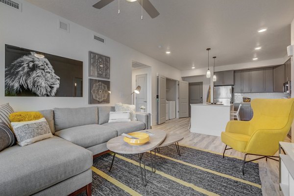Modern living room with hardwood floors and stylish furniture in Harmony3900 Apartments