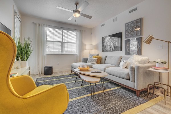 Cozy living room with natural light and modern furnishings at Harmony3900 Apartments