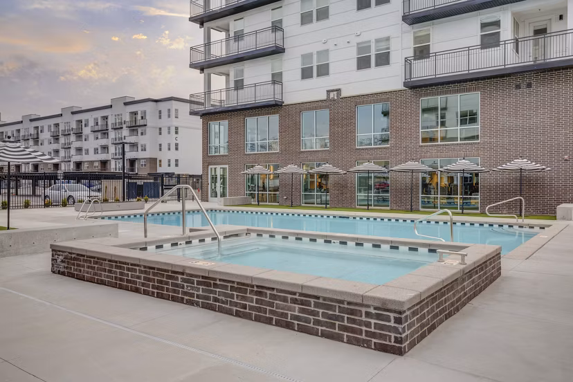 Resort-style pool surrounded by lush landscaping at Harmony3900 Apartments