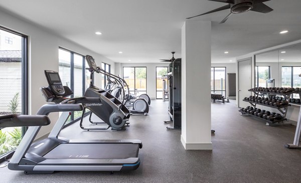 State-of-the-art fitness center equipped with modern cardio machines at Bellrock Memorial Apartments