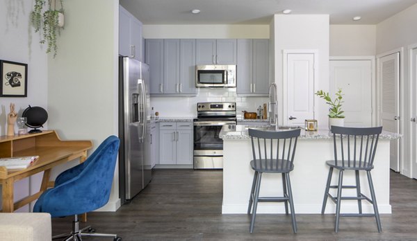Modern kitchen with sleek appliances and home office space at Bellrock Memorial Apartments