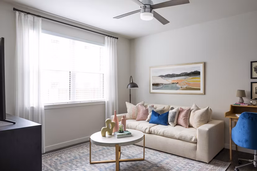Elegant living room with modern decor at Bellrock Memorial Apartments, featuring plush seating and abundant natural light