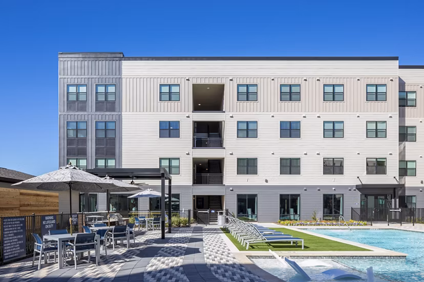 Outdoor grill area and patio by the pool at Bellrock Memorial Apartments, perfect for leisure and entertainment