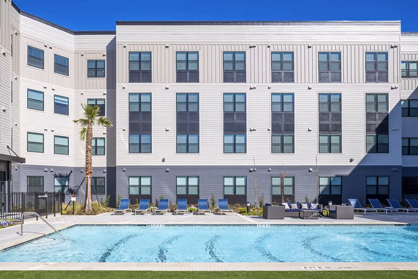 Resort-style pool surrounded by lush landscaping at Bellrock Memorial Apartments