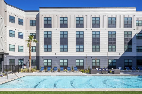 Resort-style pool surrounded by lush landscaping at Bellrock Memorial Apartments