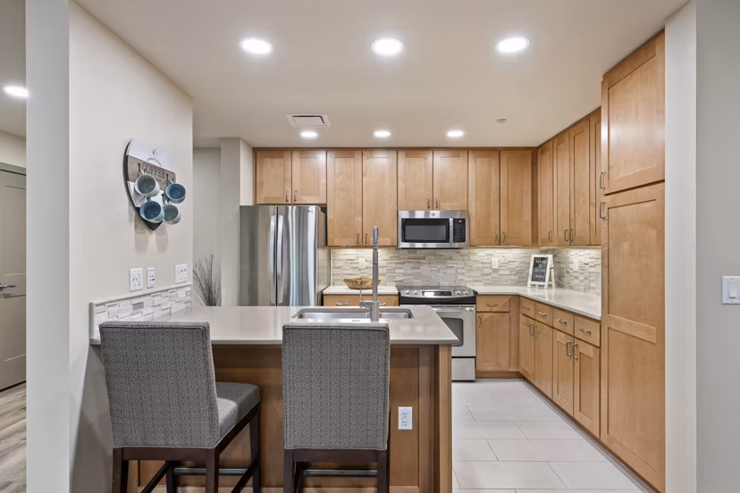 Modern kitchen with stainless steel appliances and granite countertops at City Creek Landing Apartments