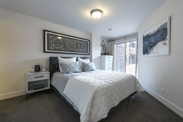 Cozy bedroom with plush bedding and modern decor at Brigham Apartments