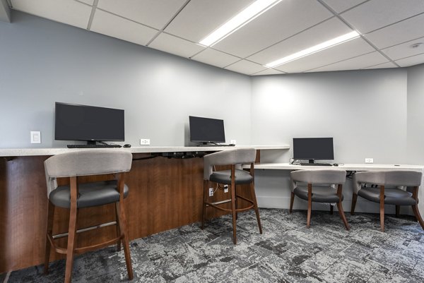 Business center featuring modern workstations and conference room at Brigham Apartments, luxury living in a central location