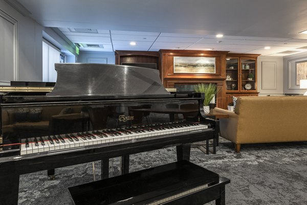Modern clubhouse featuring a lounge area and fireplace at Brigham Apartments