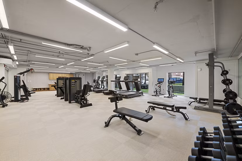 Yoga/spin studio with modern equipment at Brigham Apartments: Luxury fitness amenities in urban living environment