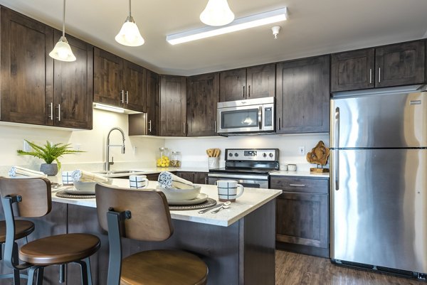 Modern kitchen with sleek cabinetry and stainless steel appliances at Brigham Apartments