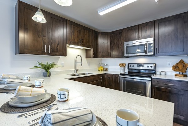 Modern kitchen with stainless steel appliances at Brigham Apartments