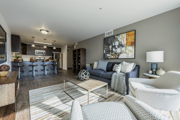 Spacious living room featuring modern decor and natural light at Brigham Apartments
