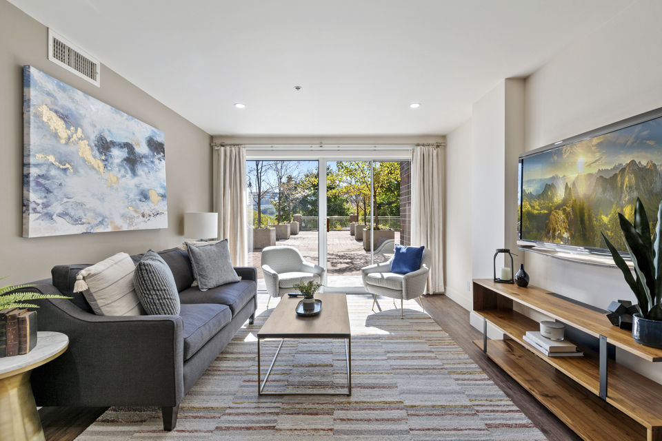 Spacious living room featuring modern decor and natural light at Brigham Apartments