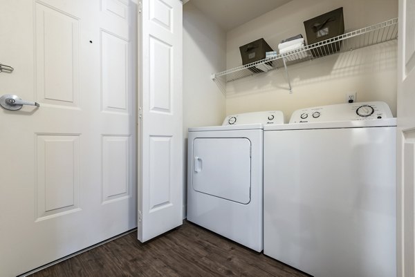 Laundry room with modern appliances at Brigham Apartments, a luxury living community by Greystar