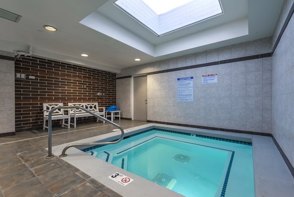Relaxing hot tub at Brigham Apartments: luxury amenity for unwinding and socializing in community setting