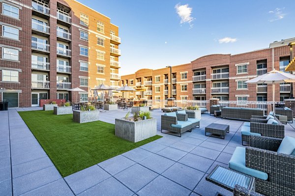 Courtyard featuring lush greenery and seating areas at Brigham Apartments
