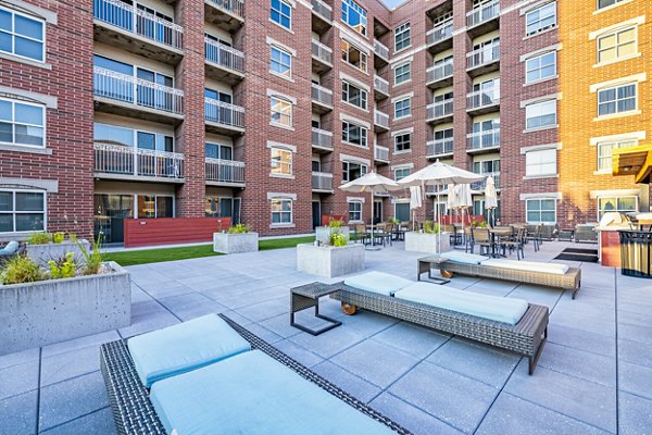 Courtyard featuring lush greenery and outdoor seating at Brigham Apartments, a luxury community