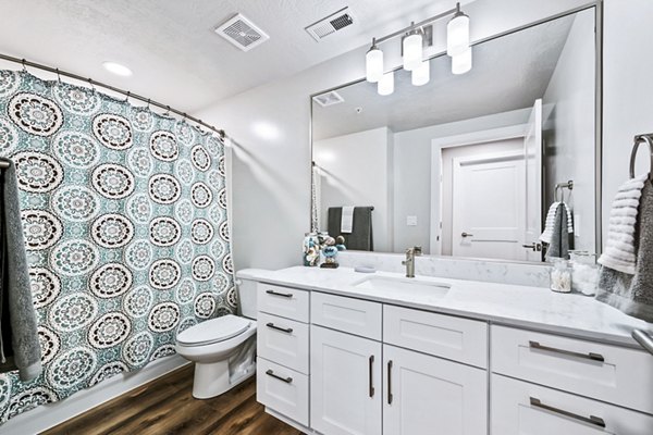 Bathroom featuring luxurious marble countertops and modern fixtures in Colonial Court Apartments