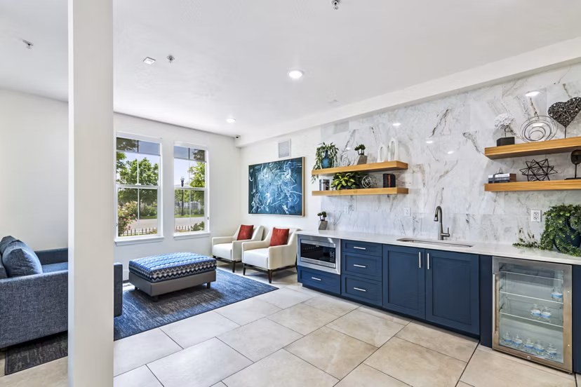 Clubhouse kitchen featuring modern appliances and ample seating at Colonial Court Apartments