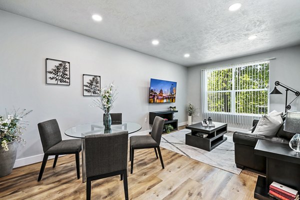 Dining room featuring elegant wooden table and modern lighting in Colonial Court Apartments