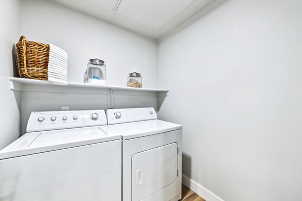 Laundry room with modern appliances at Colonial Court Apartments, a luxury Greystar property in a vibrant community