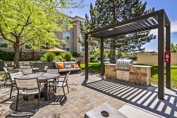 Outdoor grill area and patio with seating at Colonial Court Apartments