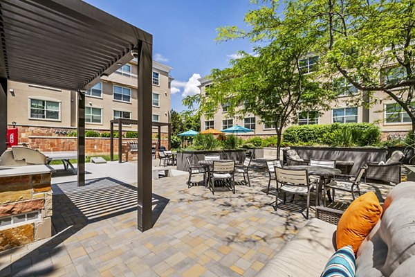 Grill area on patio with seating at Colonial Court Apartments, offering outdoor dining and relaxation space