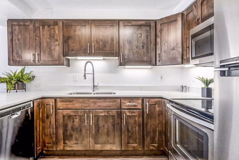 Modern kitchen with granite countertops and stainless steel appliances in Eagle Gate Apartments