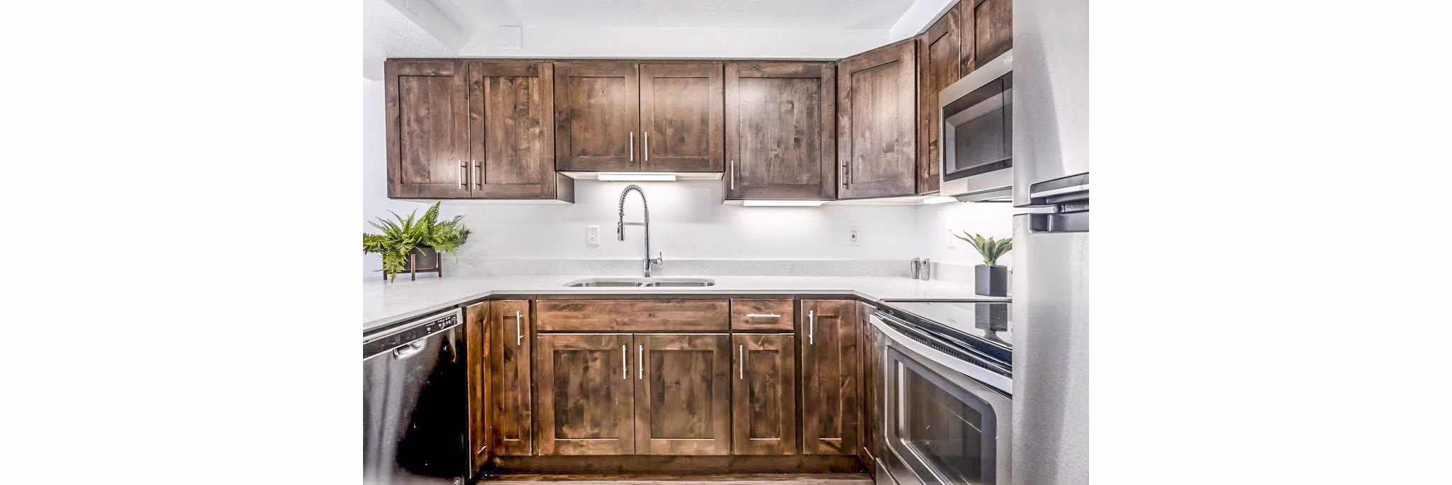 Modern kitchen with granite countertops and stainless steel appliances in Eagle Gate Apartments