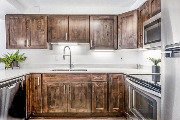 Modern kitchen with granite countertops and stainless steel appliances in Eagle Gate Apartments