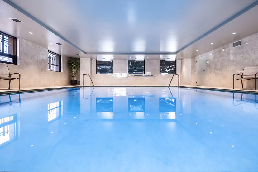 Luxurious outdoor pool area at Eagle Gate Apartments with modern seating and lush landscaping, perfect for relaxation