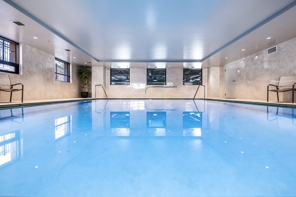 Luxurious outdoor pool area at Eagle Gate Apartments with modern seating and lush landscaping, perfect for relaxation