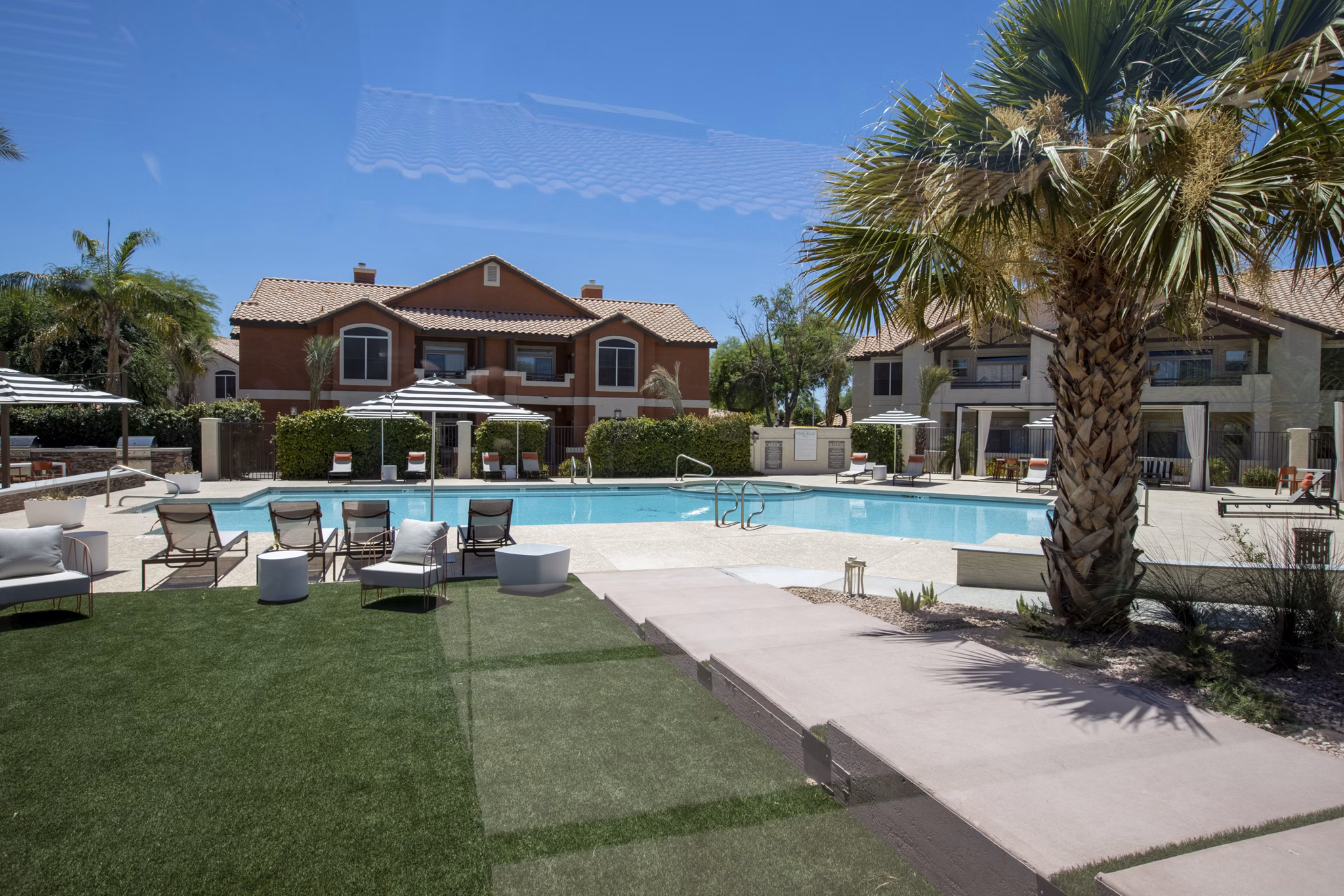 Relaxing pool area with lounge chairs at Avana Coronado Apartments, a luxury living community