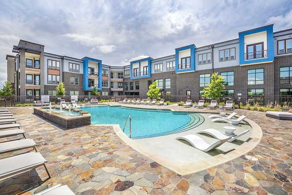 Modern outdoor pool with lounge seating at The Holston Apartments, a luxury property offering premium amenities in urban settings